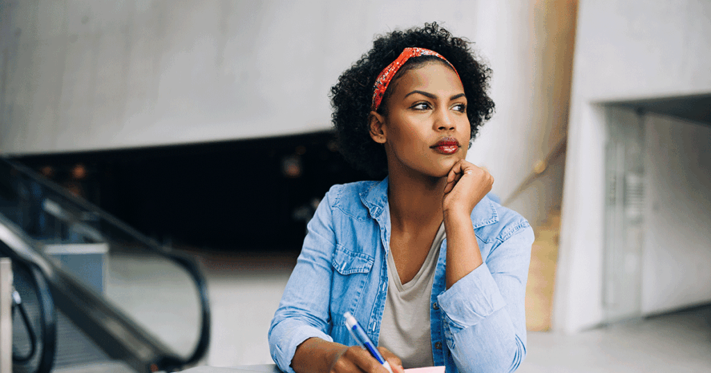 Woman reflecting on her pregnancy while preparing questions before her first trimester ultrasound.